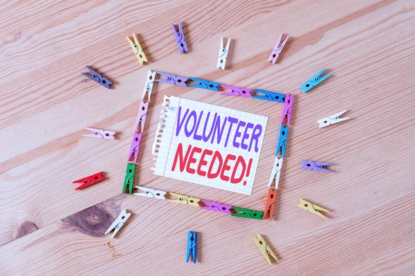 Handwriting text writing Volunteer Needed. Concept meaning asking demonstrating to work for organization without being paid Colored clothespin papers empty reminder wooden floor background office.