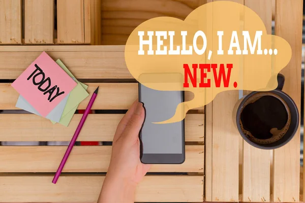 Text sign showing Hello I Am New. Conceptual photo introducing oneself in a group as fresh worker or student woman computer smartphone drink mug office supplies technological devices.
