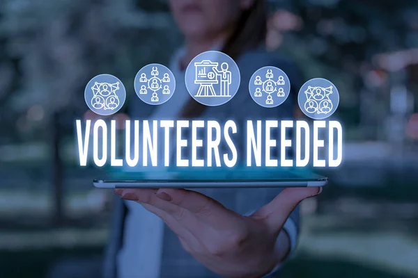 Handwriting text Volunteers Needed. Concept meaning need work or help for organization without being paid Woman wear formal work suit presenting presentation using smart device.