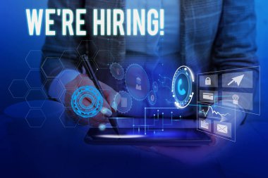 İşe Aldığımızı gösteren bir metin işareti. Başvuruların gözden geçirilmesi ve adayları bulmanın kavramsal fotoğraf süreci Kadın akıllı cihaz kullanarak sunum sunan resmi iş elbisesi giyiyor.