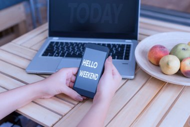 Hello Weekend gösteren kavramsal el yazısı. Dizüstü akıllı telefon ve ofis malzemeleri teknolojisi ile Getaway Macera Cuma Pozitiflik Gevşeme Daveti kadın vitrine İş fotoğraf.