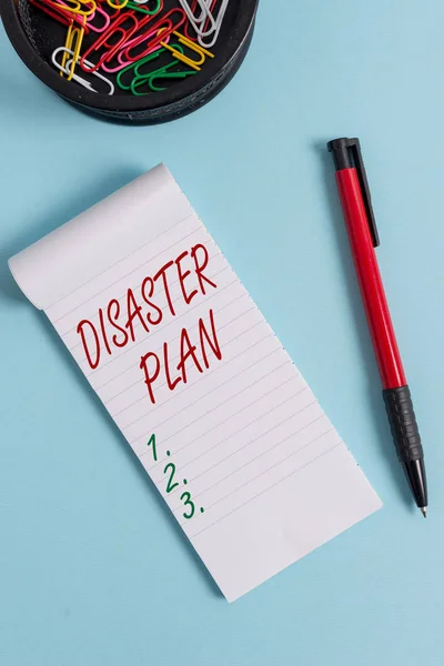 Escribiendo una nota que muestra el Plan de Desastres. Exhibición de fotos de negocios Responda a la supervivencia de preparación para emergencias y el kit de primeros auxilios Cuaderno y estacionario con el ratón sobre el telón de fondo pastel . — Foto de Stock