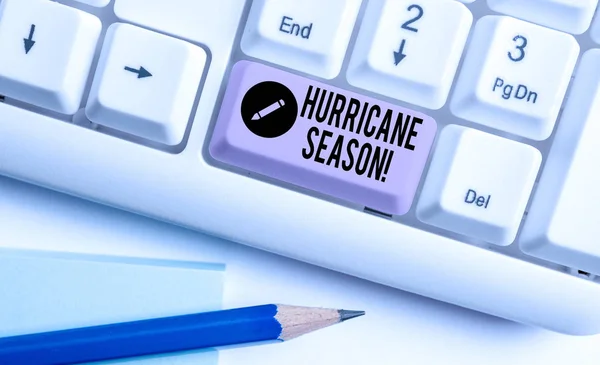 Handwriting text Hurricane Season. Concept meaning time when most tropical cyclones are expected to develop White pc keyboard with empty note paper above white background key copy space.