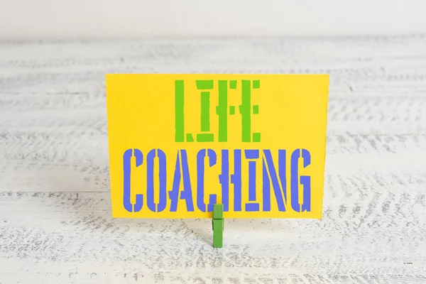Text sign showing Life Coaching. Conceptual photo Improve Lives by Challenges Encourages us in our Careers Green clothespin white wood background colored paper reminder office supply.