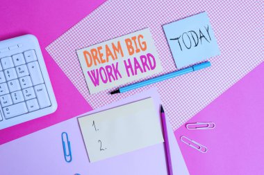 El yazısı metin Dream Big Work Hard. Kavram anlamı Kendinize inanın ve hayalleri ve hedefleri takip renkli düz tablo üzerine yerleştirilen ekipman ve bilgisayar malzemeleri yazma.