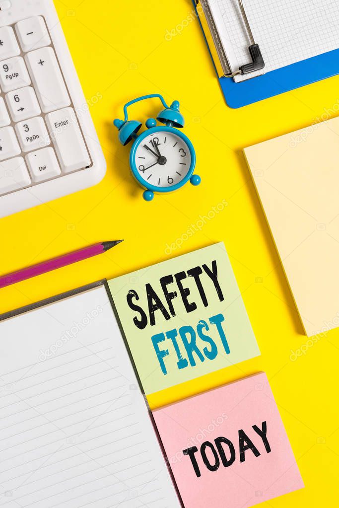 Conceptual hand writing showing Safety First. Business photo text used to say that the most important thing is to be safe Crumpled white paper on table clock mobile and pc keyboard.