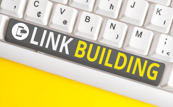 Conceptual hand writing showing Link Building. Business photo text SEO Term Exchange Links Acquire Hyperlinks Indexed White pc keyboard with note paper above the white background.