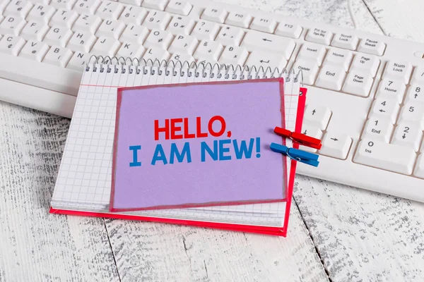 Woord tekst schrijven Hallo ik ben nieuw. Bedrijfsconcept voor het introduceren van zichzelf in een groep als nieuwe werknemer of student Notebook papier herinnering wasknijper vastgemaakt blad wit toetsenbord licht houten. — Stockfoto