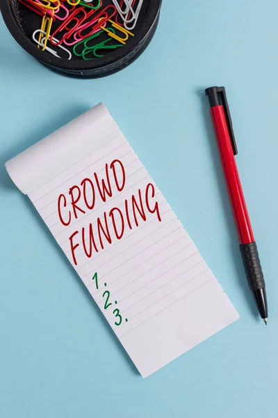 Escribiendo nota mostrando Crowd Funding. Foto de negocios mostrando Recaudación de Fondos Kickstarter Startup Pledge Plataforma Donaciones Cuaderno y estacionario con ratón sobre fondo pastel . — Foto de Stock