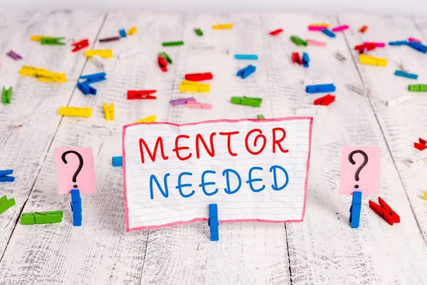 Handwriting text writing Mentor Needed. Concept meaning wanted help for more experienced or more knowledgeable demonstrating Scribbled and crumbling sheet with paper clips placed on the wooden table.