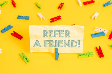 Arkadaşı Göster'i gösteren not yazma. İş fotoğraf başka birine doğrudan birini vitrine veya ona hediye Renkli clothespin kağıtları boş hatırlatma sarı zemin arka plan ofis gibi bir şey göndermek.