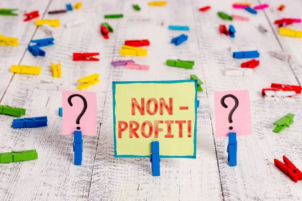 Handgeschreven tekst non-profit. Concept betekenis niet maken of uitgevoerd in de eerste plaats te maken van profit organisatie Scribbled en afbrokkelende blad met paperclips geplaatst op de houten tafel. — Stockfoto