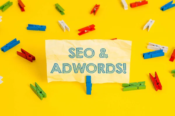 Writing note showing Seo And Adwords. Business photo showcasing they are main tools components of Search Engine Marketing Colored clothespin papers empty reminder yellow floor background office. — Stock Photo, Image