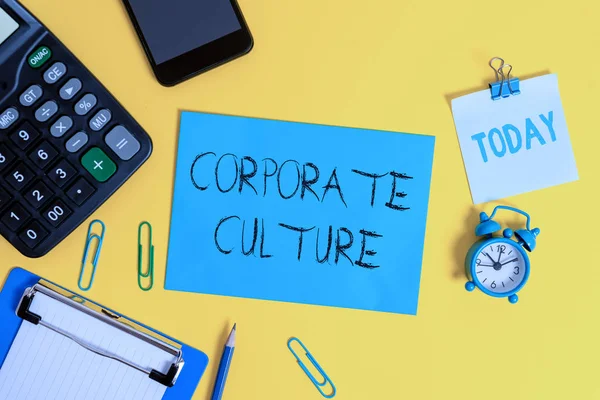 Writing note showing Corporate Culture. Business photo showcasing pervasive values and attitudes that characterize a company Clipboard sheet calculator pencil clock smartphone color background.