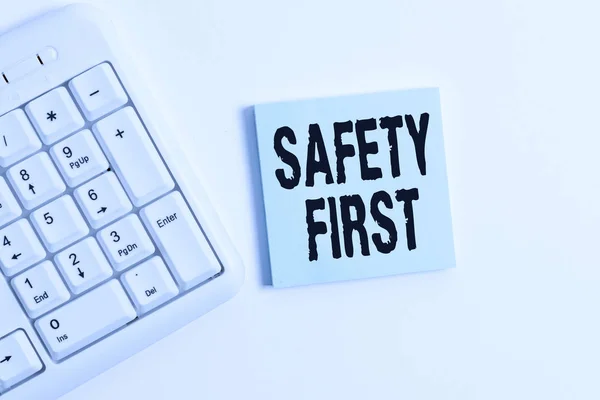Word pisanie tekstu bezpieczeństwo First. Koncepcja biznesowa używana do powiedzenia, że najważniejszą rzeczą jest bezpieczna biała klawiatura PC z pustym papierze notatki powyżej białego tła. — Zdjęcie stockowe