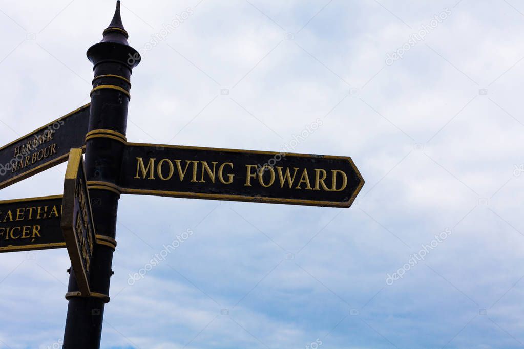 Text sign showing Moving Foward. Conceptual photo Towards a Point Move on Going Ahead Further Advance Progress Road sign on the crossroads with blue cloudy sky in the background.