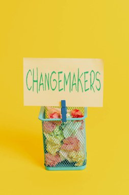 El yazısı metin Değiştiriciler. Kavram anlamı Jön Türk Influencers Acitivists Kentleşme Moda Gen X Çöp bin buruşuk kağıt clothespin boş hatırlatma ofis malzemeleri sarı.