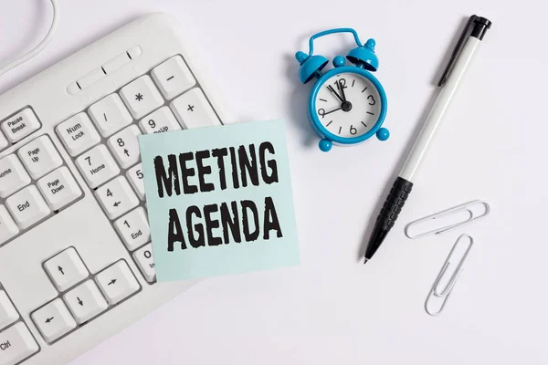 Escrita à mão conceitual mostrando Agenda da Reunião. Itens de texto de foto de negócios que os participantes esperam realizar em uma reunião Teclado de PC branco com papel de nota vazio acima do fundo branco . — Fotografia de Stock