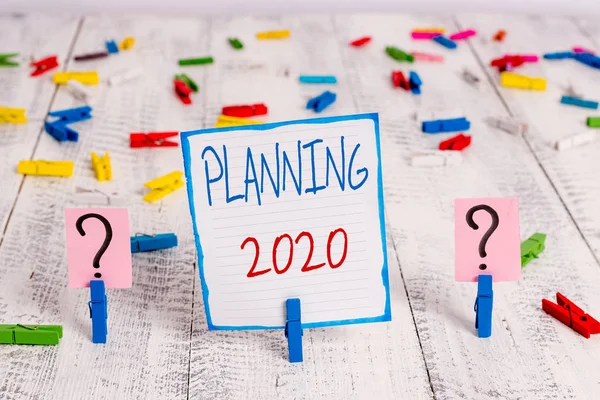 Conceptual hand writing showing Planning 2020. Business photo showcasing Begin with end in the Mind Positioning Long term Objectives Crumbling sheet with paper clips placed on the wooden table.