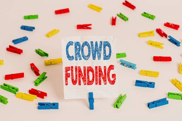 Text sign showing Crowd Funding. Conceptual photo Fundraising Kickstarter Startup Pledge Platform Donations Colored clothespin papers empty reminder white floor background office.