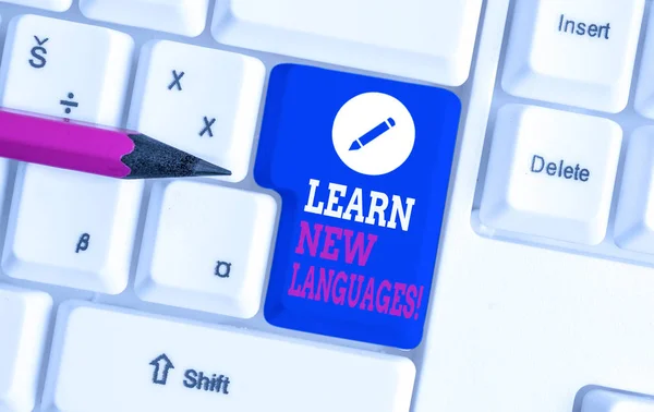 Writing note showing Learn New Languages. Business photo showcasing developing ability to communicate in foreign lang White pc keyboard with note paper above the white background. — Stock Photo, Image