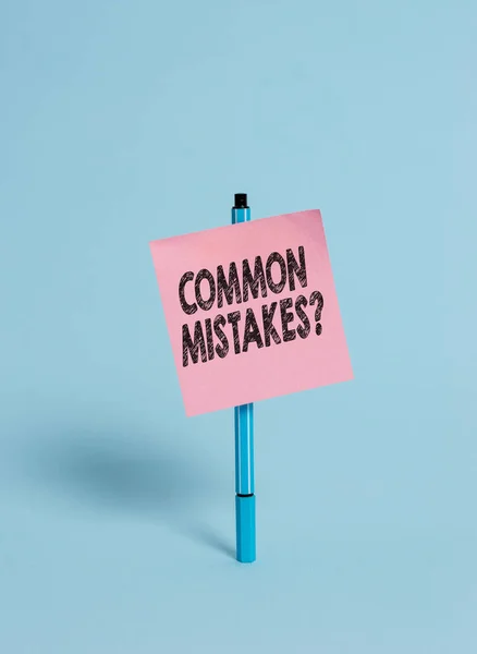 Handwriting text Common Mistakes Question. Concept meaning repeat act or judgement misguided making something wrong Ballpoint blank colored sticky note peaceful cool pastel fashion background.