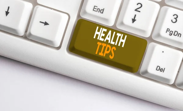 Tekstbord met tips voor de gezondheid. Conceptueel foto advies of informatie gegeven om behulpzaam te zijn bij gezond wit PC-toetsenbord met leeg notitie papier boven witte achtergrond sleutel Kopieer ruimte. — Stockfoto