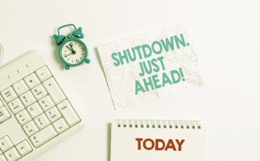 Text sign showing Shutdown Just Ahead. Conceptual photo closing factory business either short time or forever Blank paper with copy space on the table with clock and pc keyboard. clipart