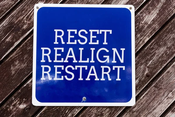 Escritura a mano escritura de texto Reset Realign Restart. Concepto que significa auditoría de la vida le ayudará a poner las cosas en perspectivas Tablero azul vacío con espacio de copia sobre fondo de madera . —  Fotos de Stock