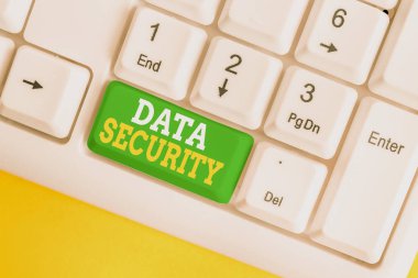 El yazısı metin Veri Güvenliği. Kavram anlamı Gizlilik Disk Şifreleme Yedekleri Şifre Kalkanbeyaz pc klavye beyaz arka plan tuşu kopyalama alanı üzerinde boş not kağıdı ile.