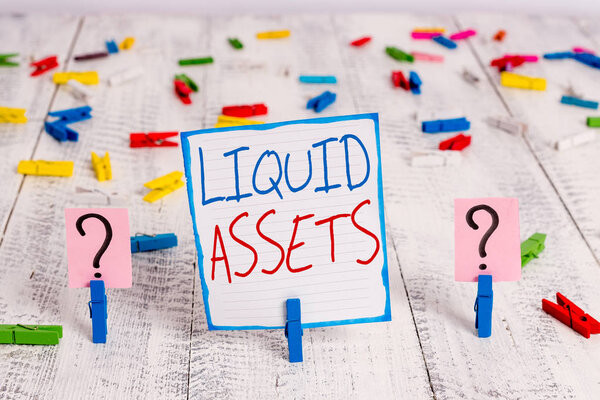 Концептуальный почерк, показывающий ликвидные активы. Ликвидность рынка Отложенная ликвидность Кредитный лист с скрепками на деревянном столе
.