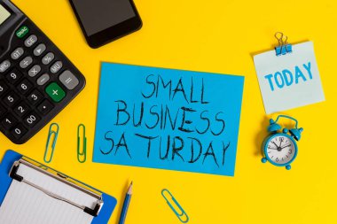 Small Business Cumartesi gösteren not yazma. Cumartesi Pano levha hesap makinesi kalem saat akıllı telefon renk arka plan sırasında düzenlenen Amerikan alışveriş tatil vitrine.