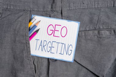 El yazısı metin Geo Hedefleme. Kavram anlamı Dijital Reklamlar Görünümler Ip Adres Adwords Kampanyalar Yer Yazma ekipmanları ve beyaz not kağıdı erkek iş pantolonu cebinde.