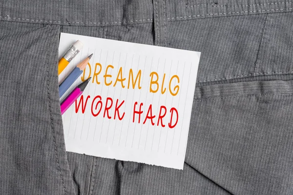 Word writing text Dream Big Work Hard. Business concept for Believe in yourself and follow the dreams and goals Writing equipment and white note paper inside pocket of man work trousers.