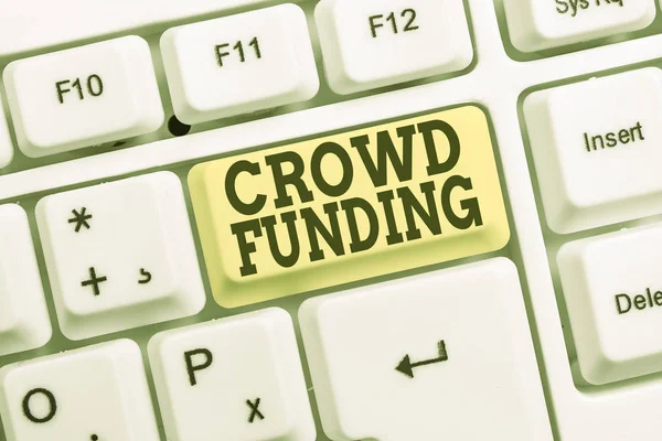 Conceptual hand writing showing Crowd Funding. Business photo text Fundraising Kickstarter Startup Pledge Platform Donations White pc keyboard with note paper above the white background. — Stock Photo, Image