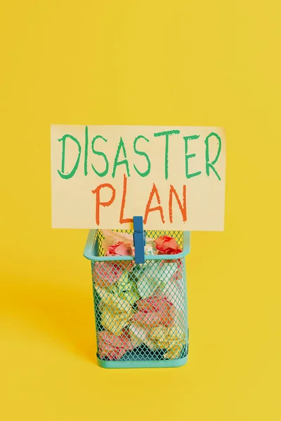Handwriting text Disaster Plan. Concept meaning Respond to Emergency Preparedness Survival and First Aid Kit Trash bin crumpled paper clothespin empty reminder office supplies yellow.