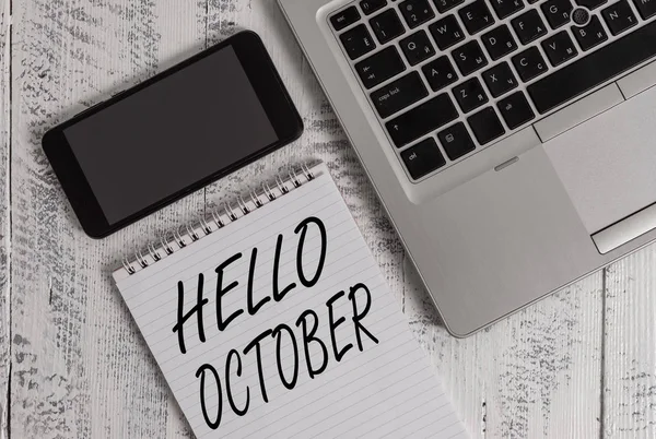 Texto de caligrafía Hola Octubre. Concepto significado Último trimestre décimo mes 30days Temporada Saludo portátil metálico blanco gobernó bloc de notas smartphone acostado mesa de madera vieja . — Foto de Stock