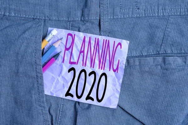 Conceptual hand writing showing Planning 2020. Business photo text Begin with end in the Mind Positioning Long term Objectives Writing equipment and purple note paper inside pocket of trousers.