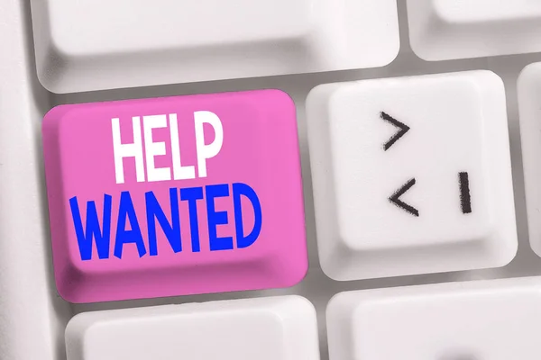 Handwriting text writing Help Wanted. Concept meaning An ad in the paper an employer places to find a new employee White pc keyboard with empty note paper above white background key copy space.