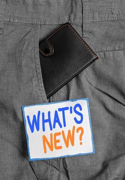 Handwriting text What S New Question. Concept meaning when you ask someone about his current live events actions Small little wallet inside man trousers front pocket near notation paper.