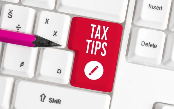 Writing note showing Tax Tips. Business photo showcasing compulsory contribution to state revenue levied by government White pc keyboard with note paper above the white background.