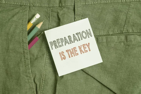 Handwriting text Preparation Is The Key. Concept meaning it reduces errors and shortens the activities Writing equipment and blue note paper inside pocket of man work trousers.