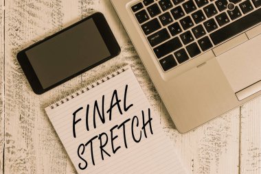 El yazısı metin Final Stretch. Konsept anlamı Son Bacak Sonuç Round Ultimate Stage Finale Yıl ender Metalik dizüstü boş eski ahşap masa yalan not defteri akıllı telefon.