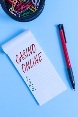Casino Online'ı gösteren not yazma. Bilgisayar Poker Oyunu Gamble Royal Bet Lotto High Stakes Notebook ve pastel fon üzerinde fare ile sabit vitrine İş fotoğraf.