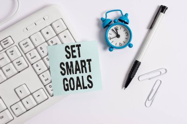 Set Smart Goals'ı gösteren kavramsal el yazısı. Beyaz arka plan üzerinde boş not kağıdı ile hedeflerin ayarında rehberlik etmek için ölçütler veren iş fotoğraf metin.