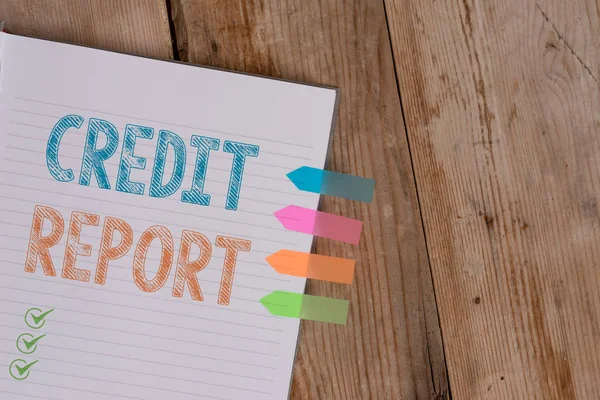 Handwriting text writing Credit Report. Concept meaning Borrowing Rap Sheet Bill and Dues Payment Score Debt History Striped note book four colored arrow banners reminder wooden background.