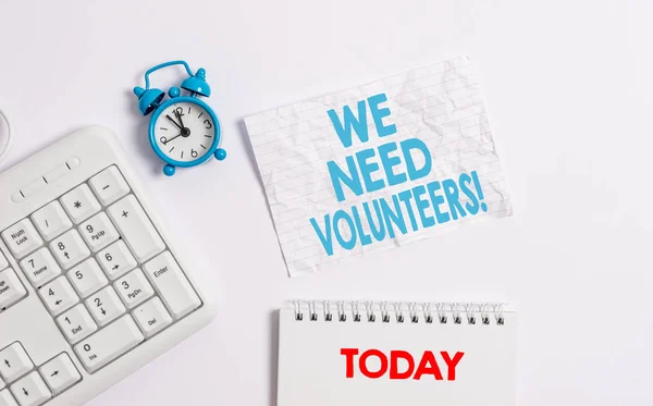 Text sign showing We Need Volunteers. Conceptual photo someone who does work without being paid for it Blank paper with copy space on the table with clock and pc keyboard. — Stock Photo, Image