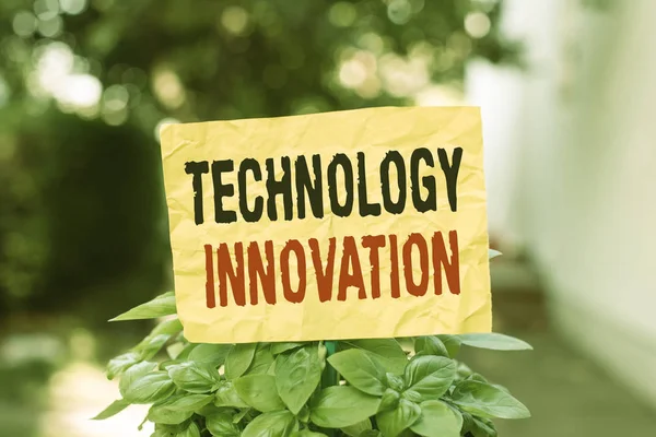 Word writing text Technology Innovation. Business concept for significant technological changes of products Plain empty paper attached to a stick and placed in the green leafy plants.