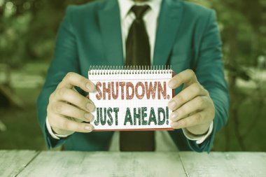 Word yazma metni Shutdown Just Ahead. Fabrika iş kapatma için iş kavramı ya kısa bir süre ya da sonsuza kadar Man önünde kopya alanı ile boş kağıt tutar.