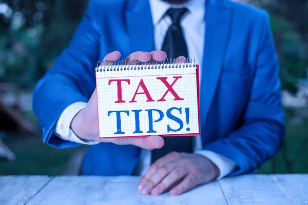 Handschriftliches Schreiben von Steuertipps. Konzept der Zwangsabgabe auf staatliche Einnahmen, die von der Regierung erhoben wird, hält leeres Papier mit Kopierplatz vor sich. — Stockfoto